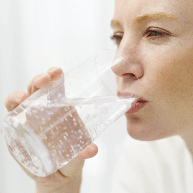 A woman drinking magnesium oil diluted in water