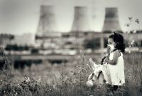 Innocent child in a respiratory mask with a doll in her hands walking against power station polluting air. Ecological theme.