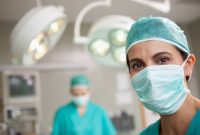 Surgeon standing in front of a colleague in a surgical room