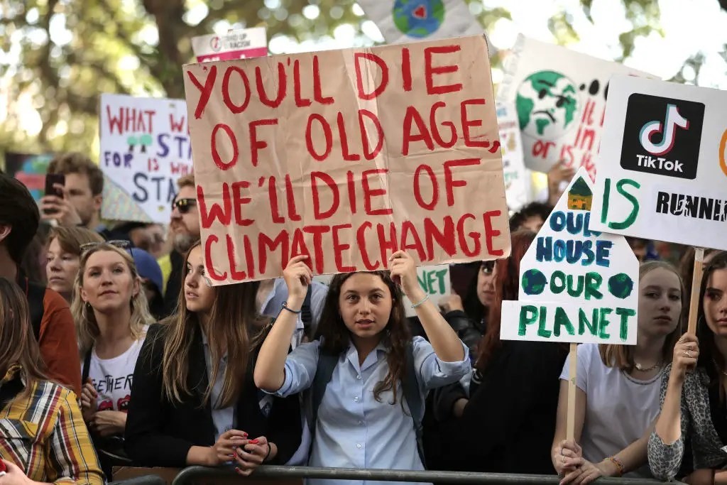 young people holding sign in protest against climate change image
