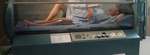 A man lying inside a hyperbaric oxygen therapy machine