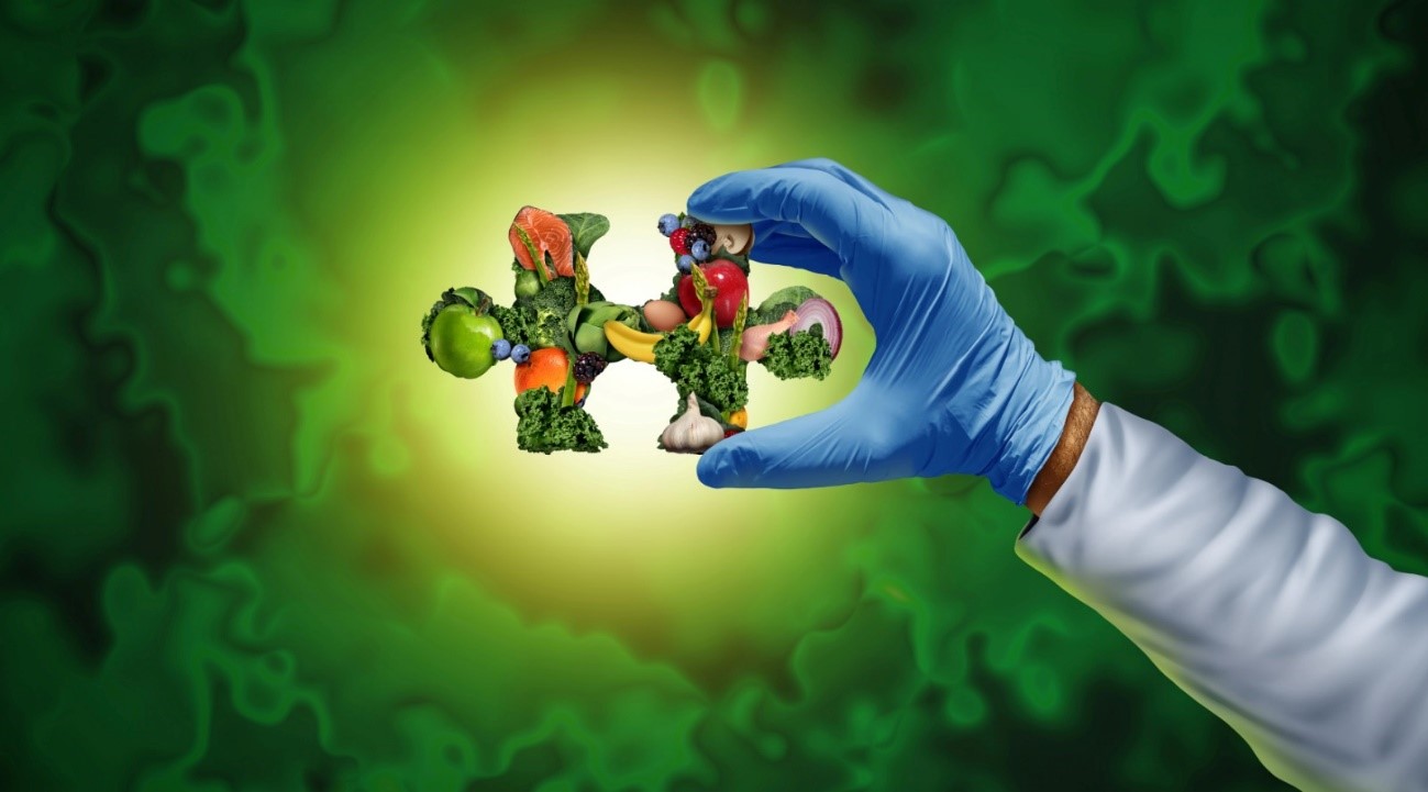 Gloved hand holding a DNA shape made of fruits and vegetables against a green background.
