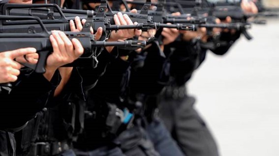 Line of uniformed individuals holding rifles aimed forward.
