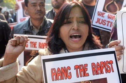 Woman holding a protest sign demanding justice for rape victims during a public demonstration.
