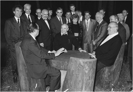 Black-and-white historical photograph of Mikhail Gorbachev discussing German reunification with German and Soviet officials in July 1990.